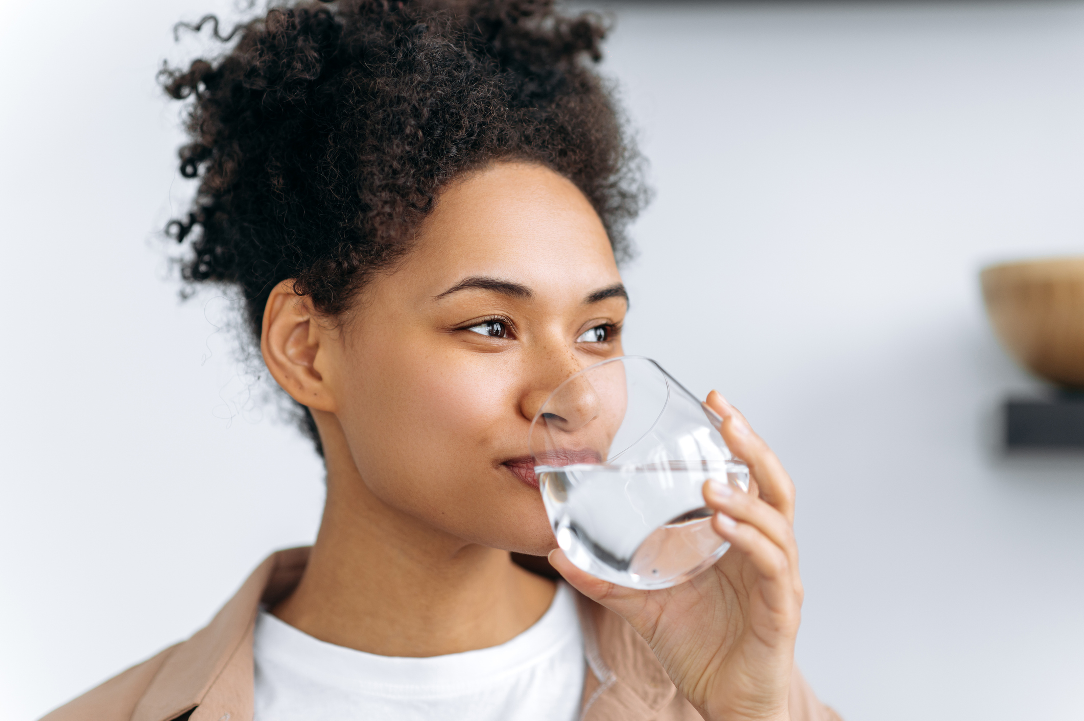 woman drinks a glass of water at home