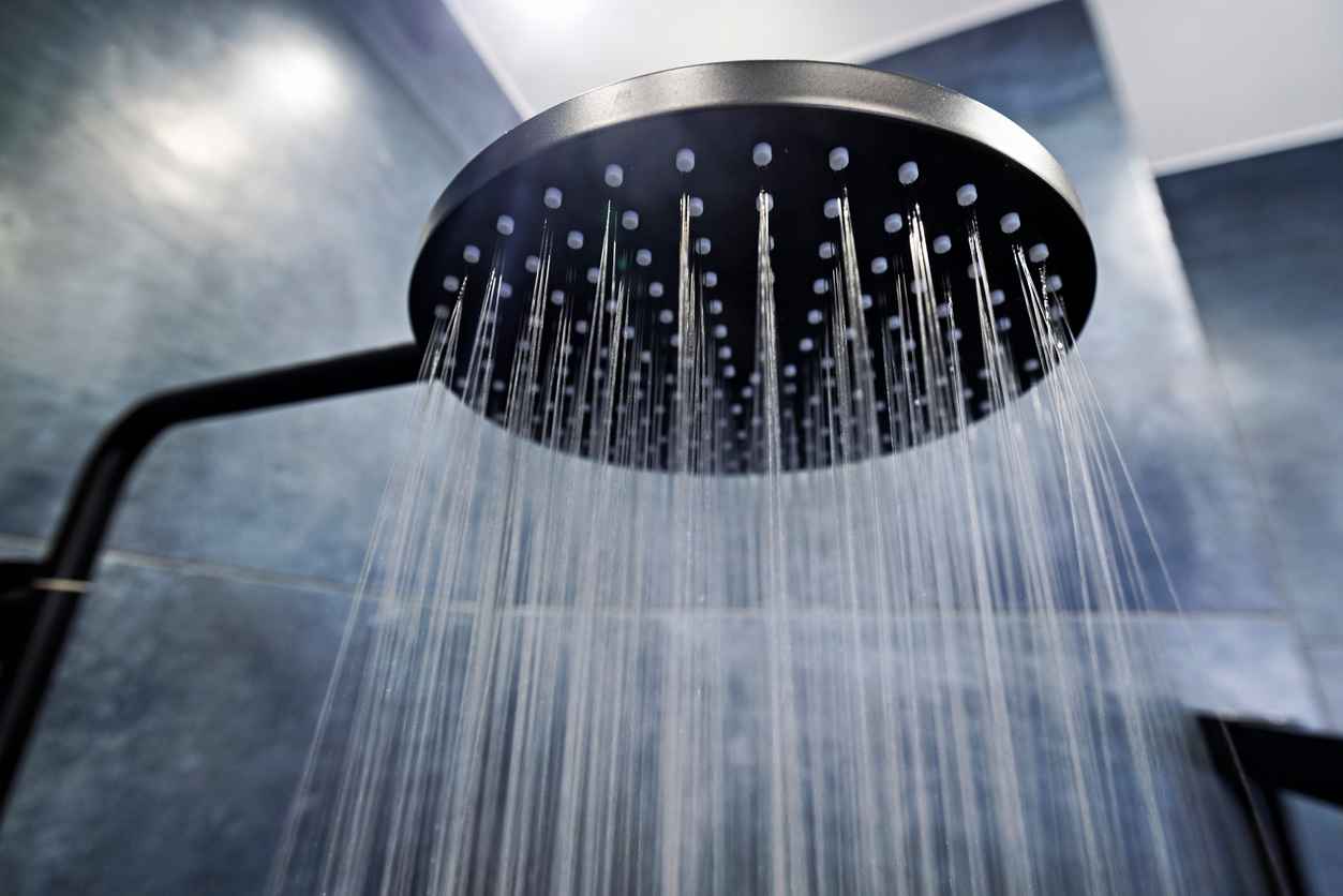 Modern luxury bathroom. Water running from a black rain shower head.